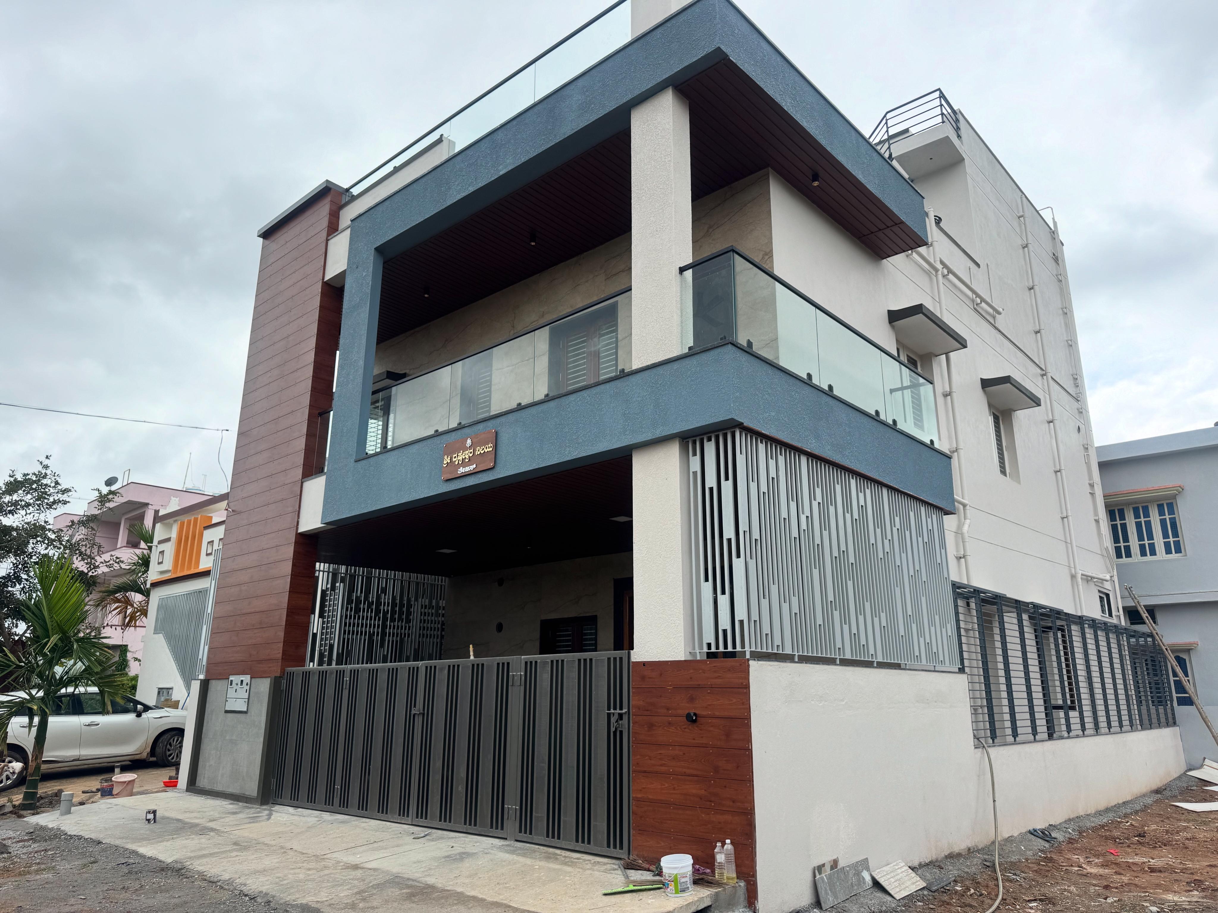 Modern residential exterior with glass balcony and gate design