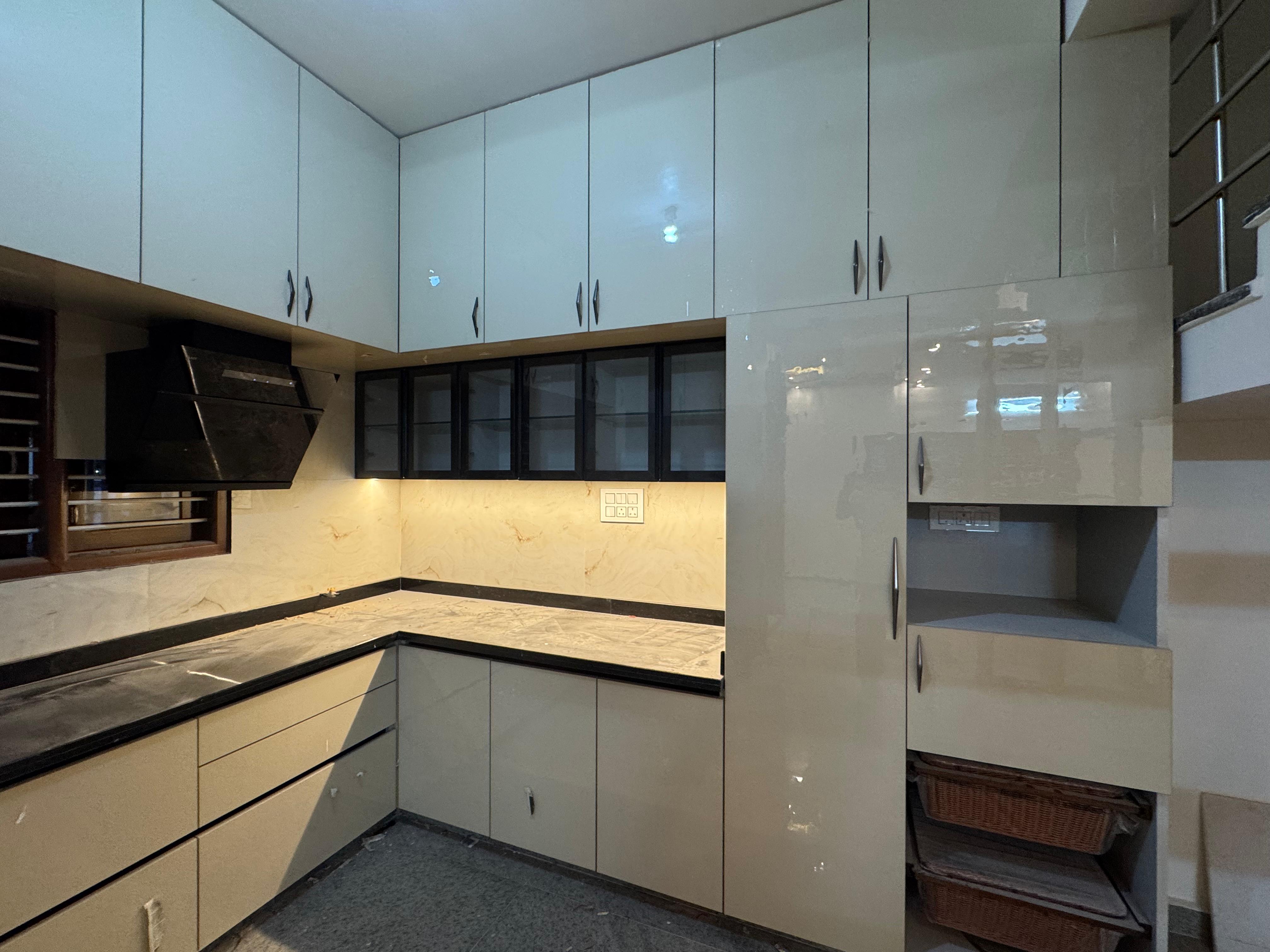 Modular kitchen with glossy cabinets and marble backsplash