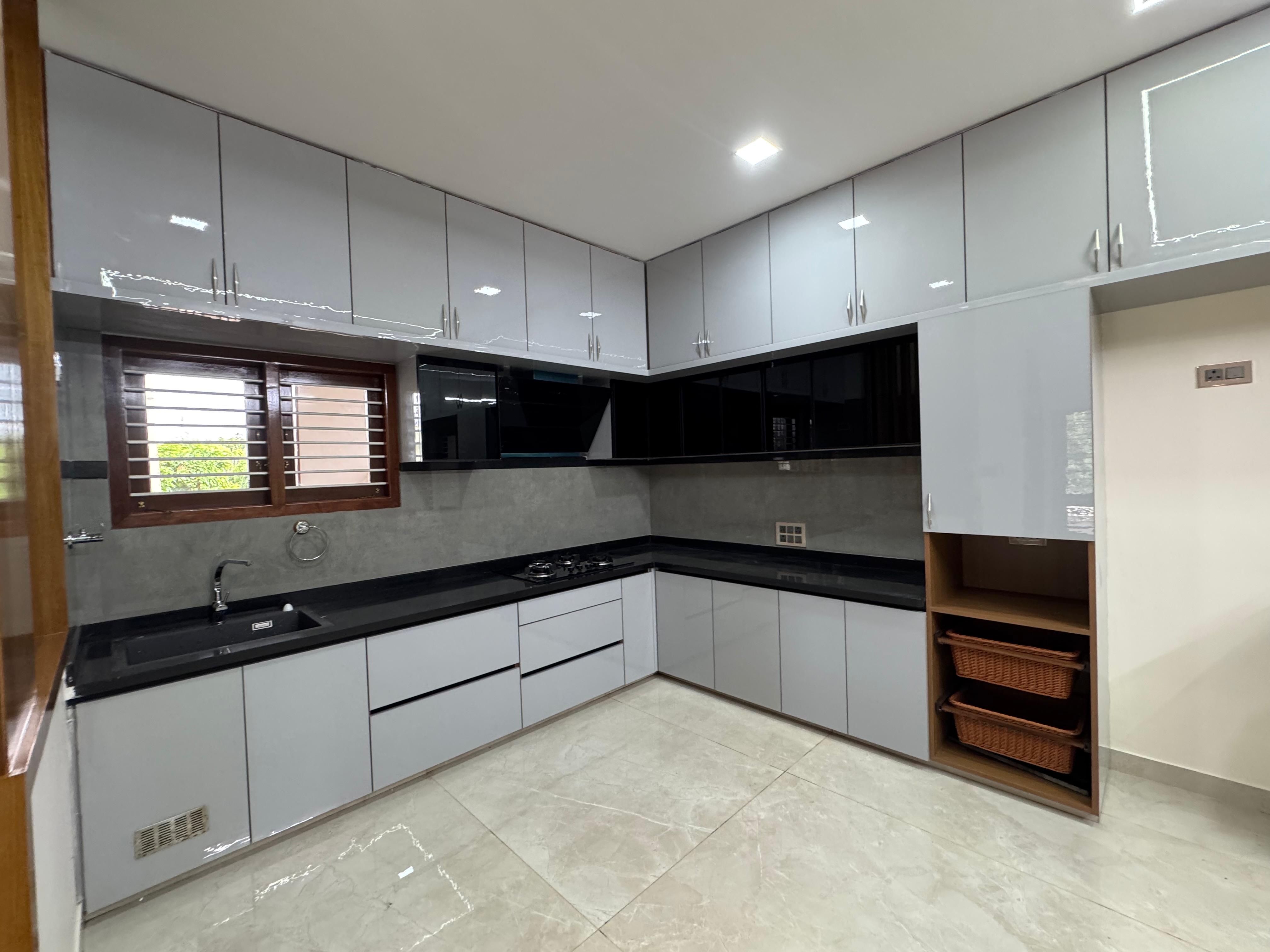 Completed L-shaped modular kitchen with black countertop