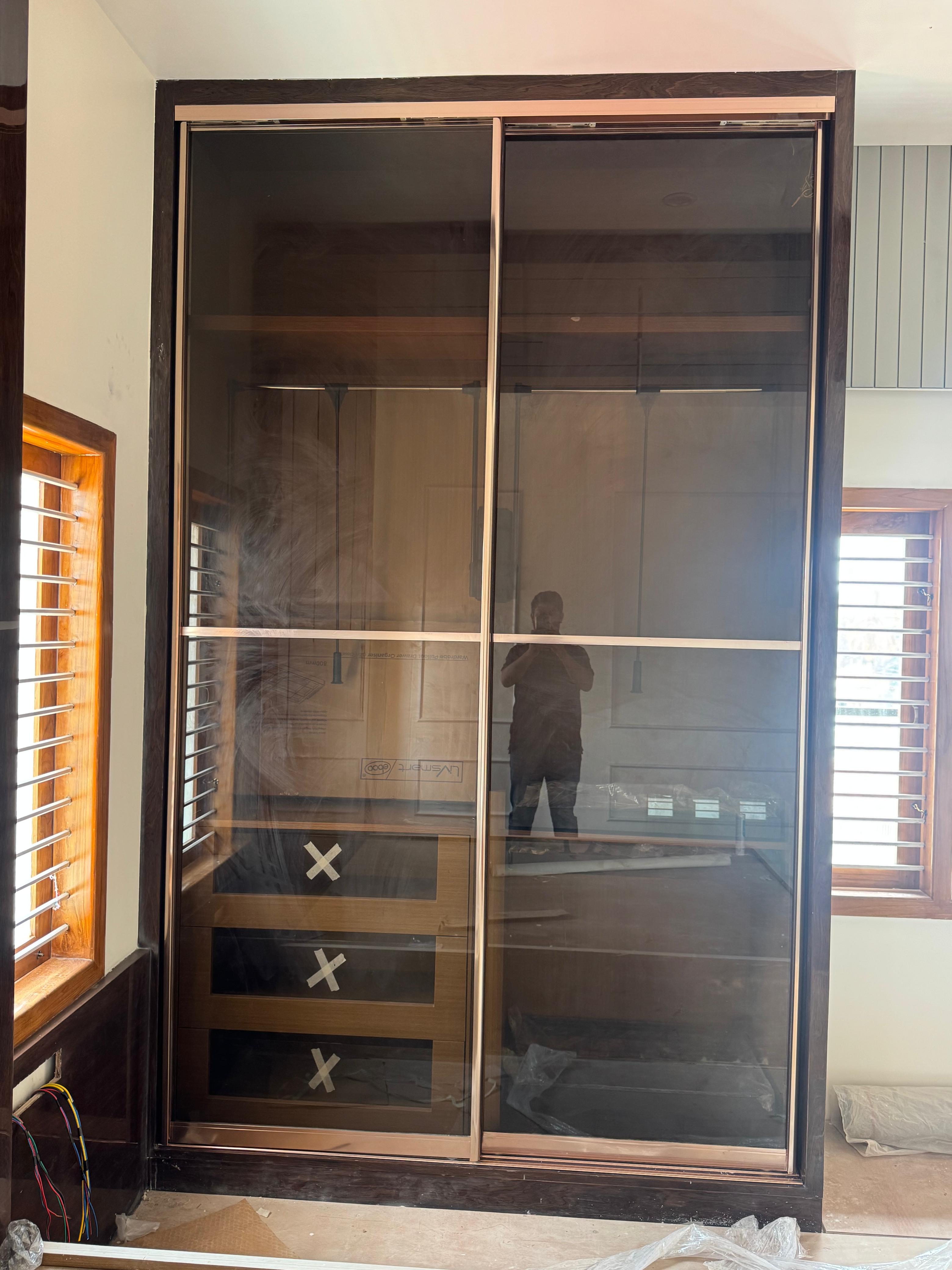 Glass sliding wardrobe with dark frame