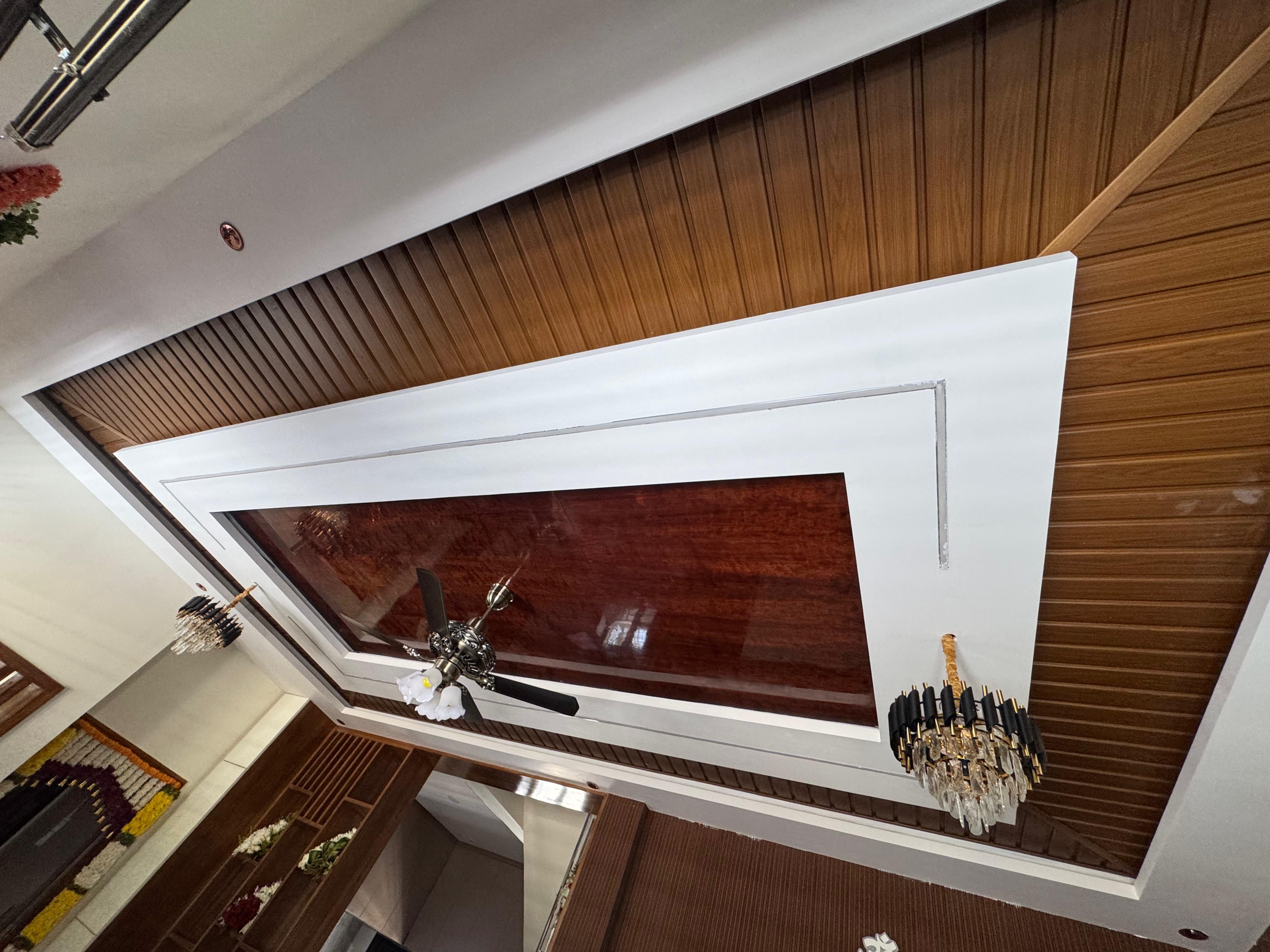 Living room ceiling with wood panel and chandelier